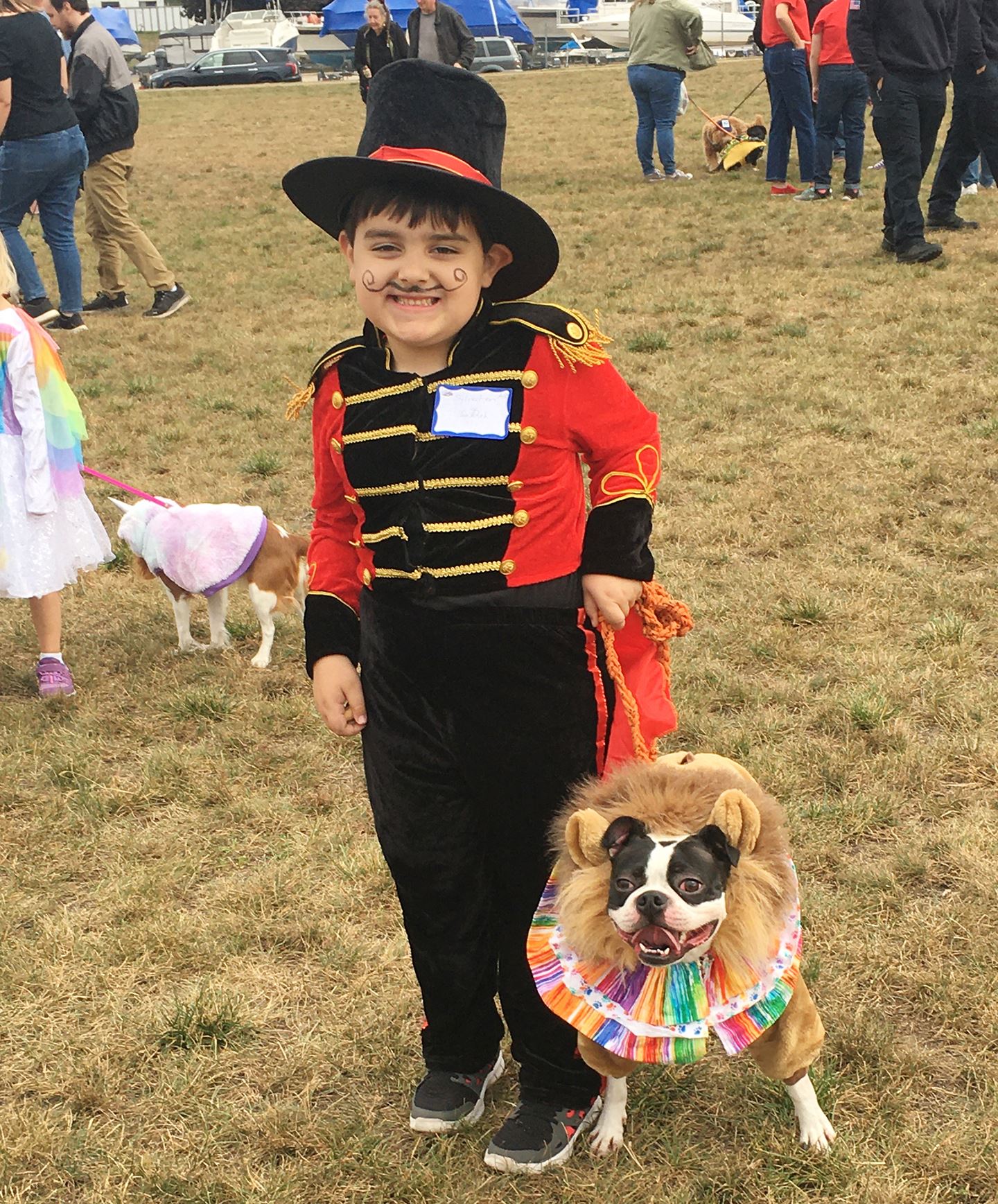 Photo of a boy dressed as a ring master with his dog dressed as a lion